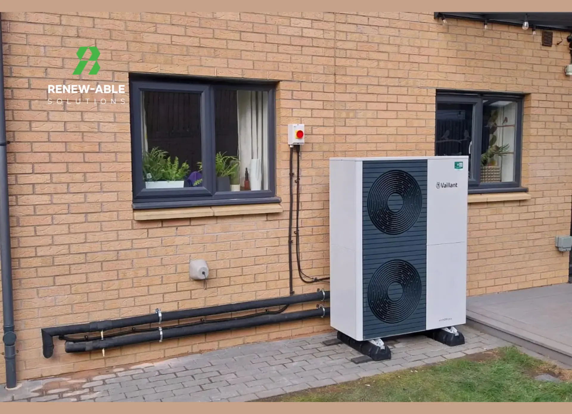 Vaillant air source heat pump installed beside a brick house