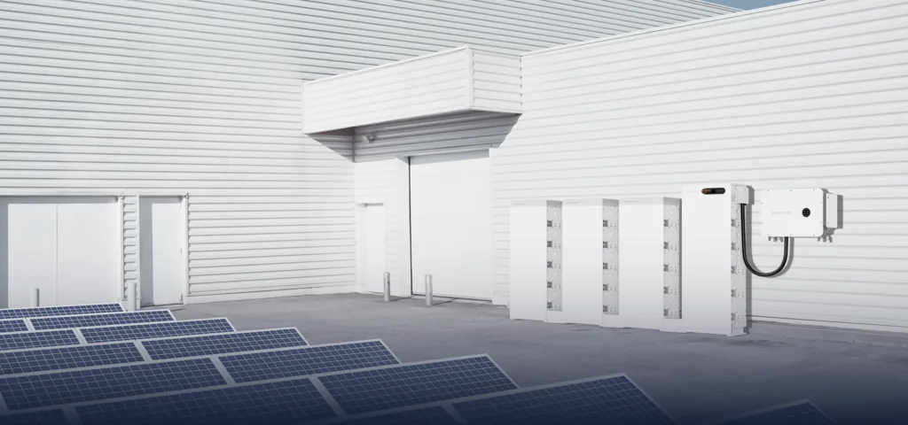 Manufacturer rendering of Sigenergy SigenStack commercial battery storage beside a building and solar panels