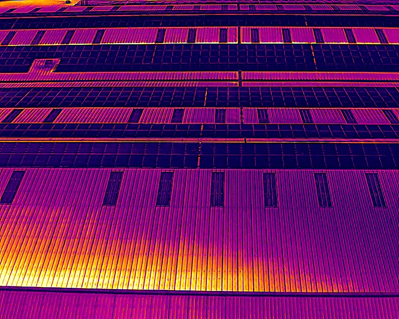 Aerial thermal survey showing temperature patterns across commercial rooftop solar panels