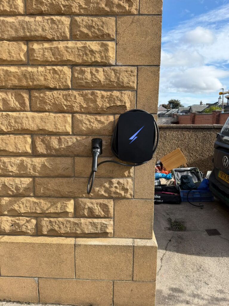 Black Hypervolt Home 3 Pro EV charger mounted on a sandstone wall in Joppa, Edinburgh, installed by Renew-Able Solutions.