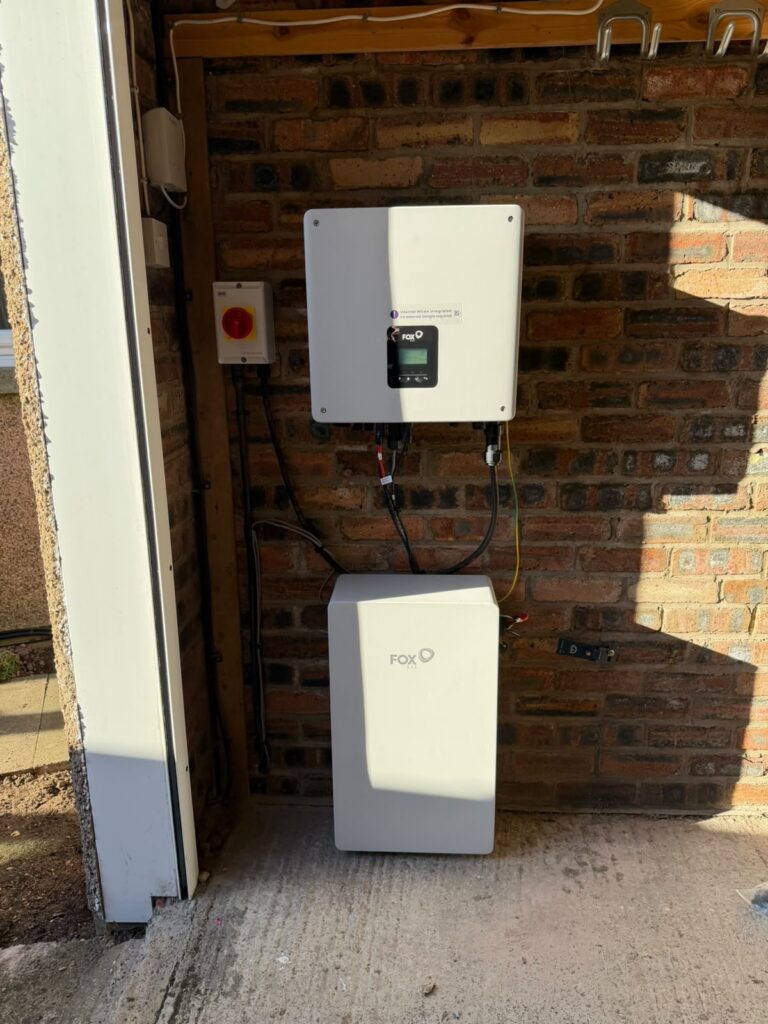 Fox ESS inverter mounted above an EP6 battery on a garage brick wall in Haddington, East Lothian
