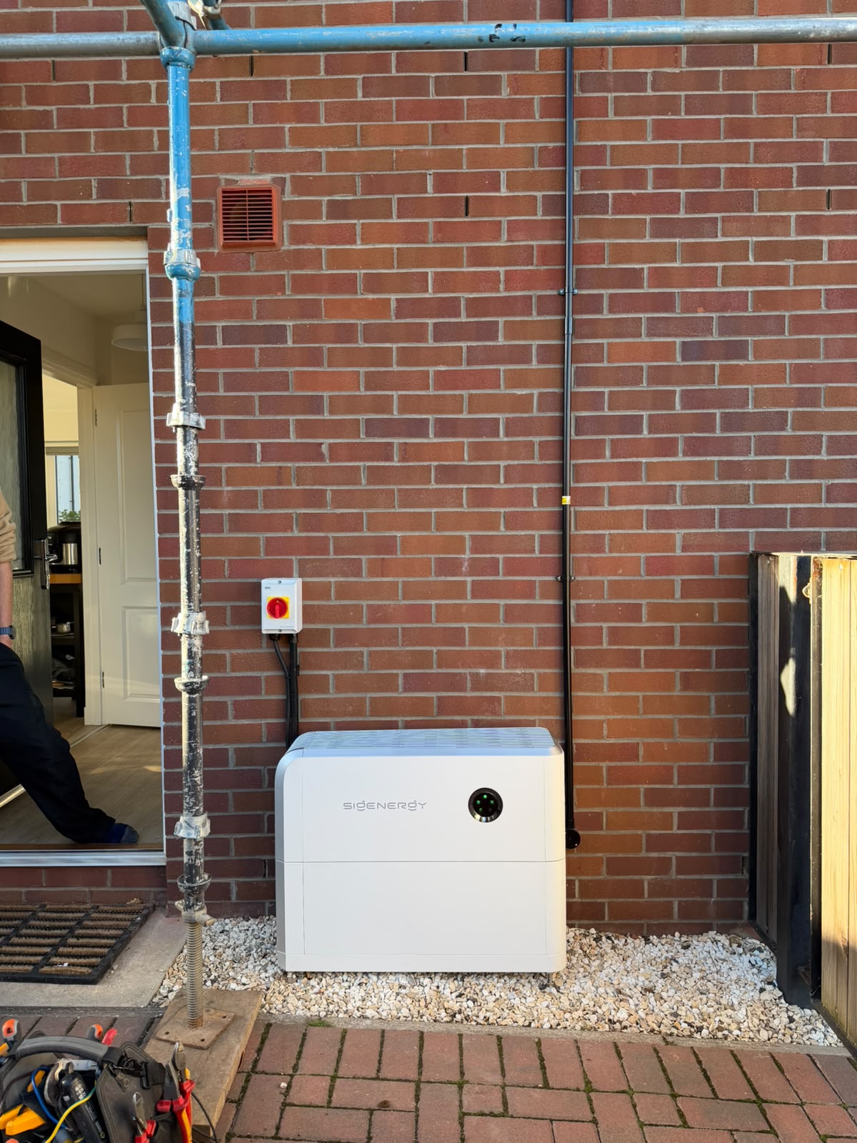 Sigenergy hybrid inverter and battery installed against an external brick wall as part of an AIKO solar panel upgrade