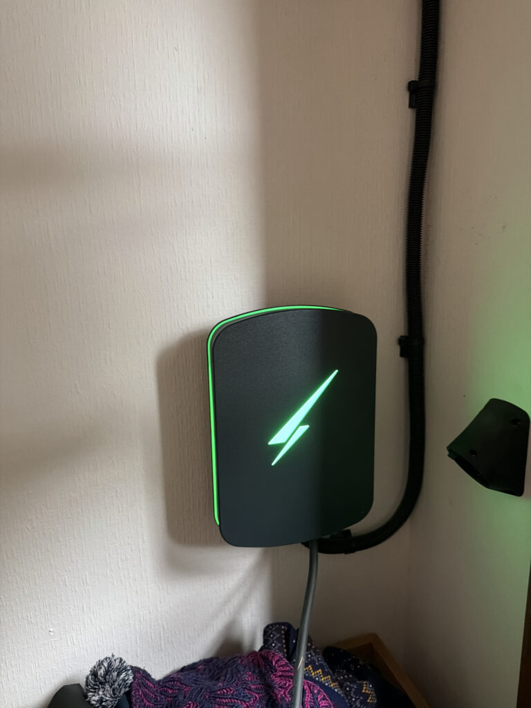 Close-up of the Hypervolt Home 3 Pro charger with green illuminated logo installed at a home in St Andrews, Fife.