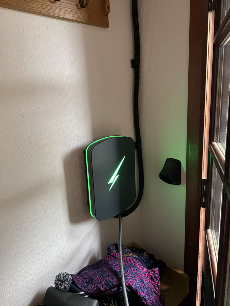 Hypervolt Home 3 Pro charger mounted beside a doorway, with its cable route and connector holder visible.